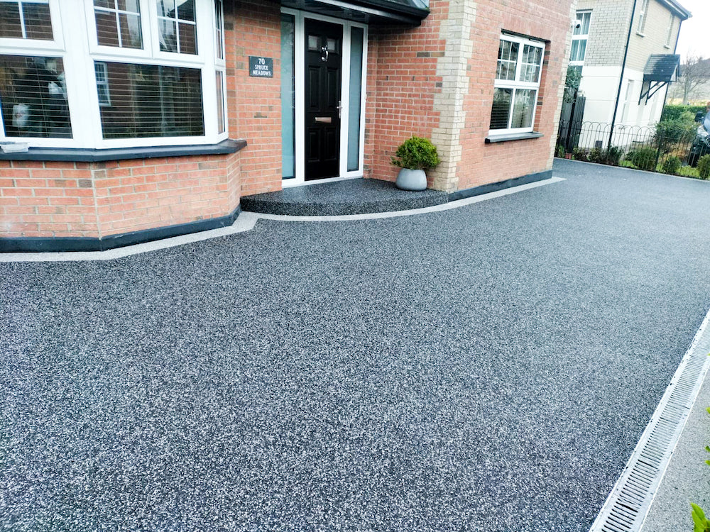 Dark resin driveway with a block paved border in Wigan